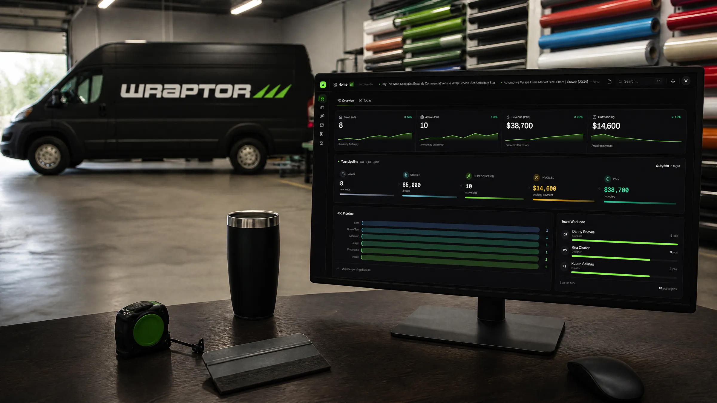 A wrap shop owner's dashboard on screen, the wrapped Overlam van on the shop floor behind it